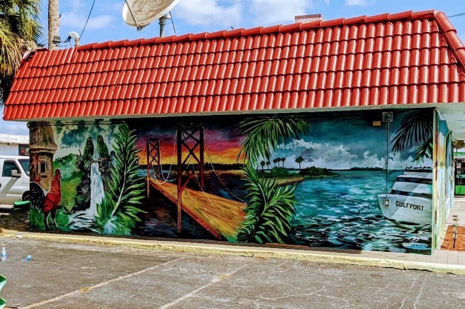 Julio's Empanadas restaurant exterior featuring the hand-painted Gulfport waterway mural with palm trees and Sunshine Skyway bridge